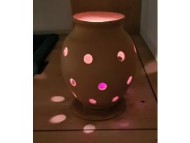 Wurmkomposter mit einer brennenden Kerze darin